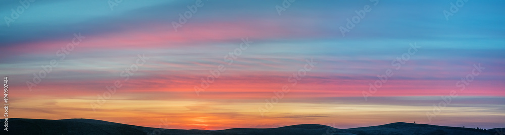 Obraz premium Picturesque sunset in the mountains, hills on the horizon, panoramic view