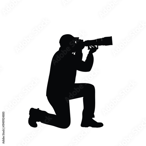 Photographer kneeling with camera and long lens, taking picture silhouette