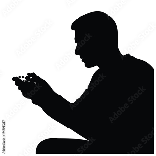 Silhouette of man holding gaming controller while sitting in profile