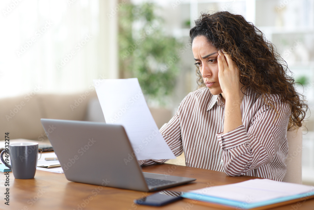 Fototapeta premium Worried adult freelance worker checking inform working at home