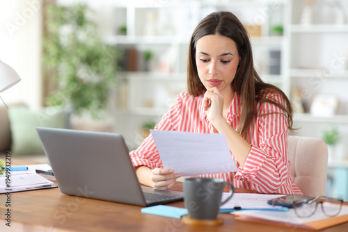 Photos Pensive self employed reading contract working at home