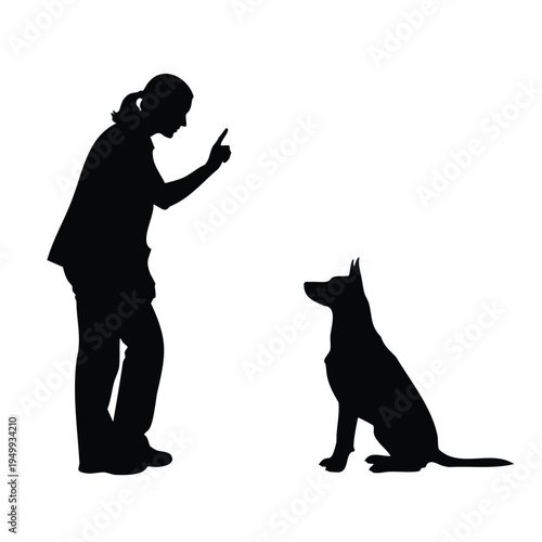 Silhouette of woman training dog, pointing finger