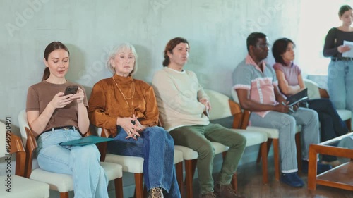  Group of people are waiting for their turn for an interview at the reception area in the office. Job seekers preparing for an interview with a recruitment manager at a marketing company