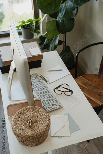 Modern Home Office Desk Detail With Desktop Monitor, Eyeglasses, Notes, And Greenery