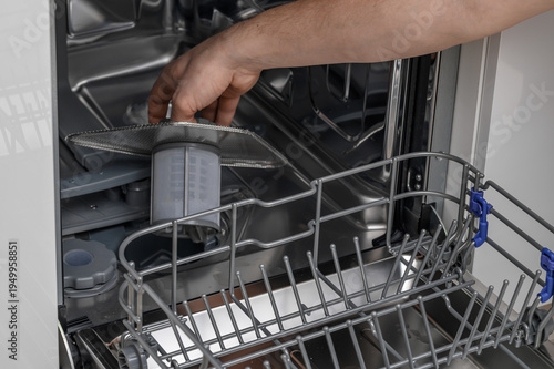 Replacing the filter in a home dishwasher, close-up of the removable filter