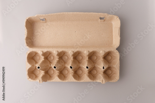 Empty cardboard egg carton open top view on grey background. Eco friendly recycled paper packaging for grocery store poultry product organic farming delivery sustainability zero waste concept