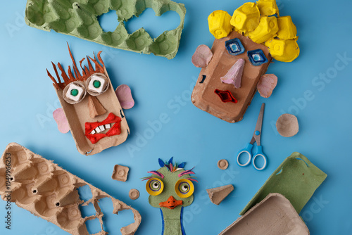 Eco friendly kids craft using recycled egg carton paper scissors blue backdrop. Sustainable art project for elementary school environmental education diy hobby creative therapy content