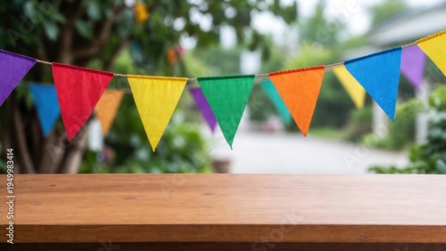 Bright triangular flags hang above a wooden table. Colors glow vividly against a blurred garden backdrop. Sunlight enhances the cheerful, festive mood. Perfect for birthdays, parties