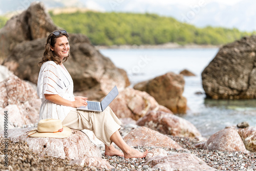 Wallpaper Mural Female freelancer with laptop on the sea coast Torontodigital.ca