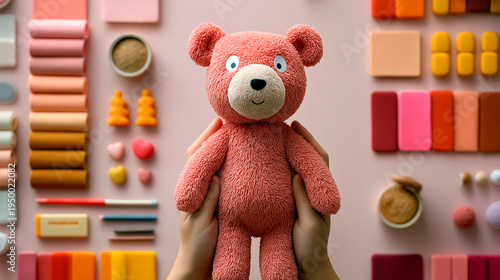 Pink teddy bear plush toy held in hands on colorful background playful childhood nostalgia kidult concept