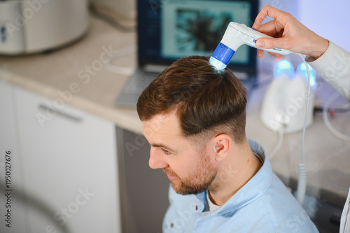 Konstfotografi A trichologist examines the hair of a man who begins alopecia