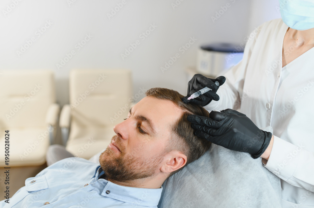 Fototapeta premium Side view of handsome man getting hair treatment at beauty salon. Man having mesotherapy session at aesthetic clinic, therapist hands in gloves making injection in scalp