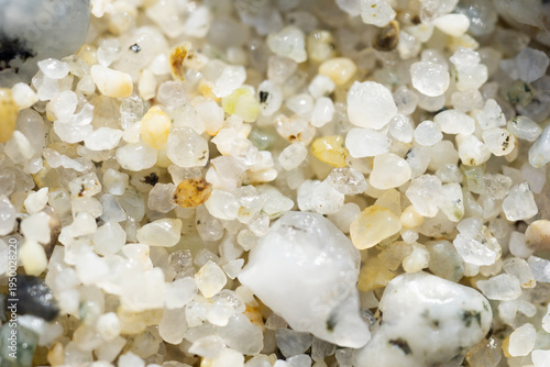 Fotografía macro shot of white and clear sand grains on a beach, detailed texture of small pebbles and minerals under bright light, concept of geology, nature, environment