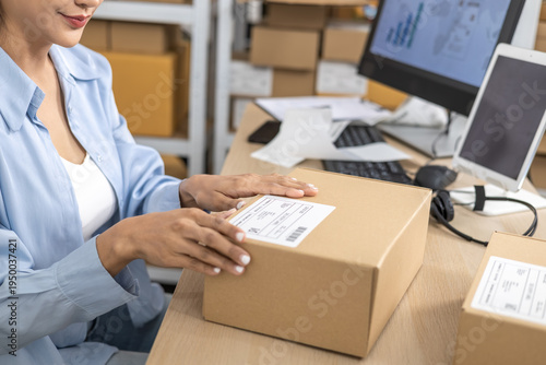 Obraz na plátně Small business warehouse scene of worker apply shipping label on parcel and tapi