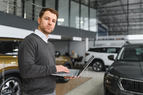 Φωτογραφία car dealer principal standing in showroom