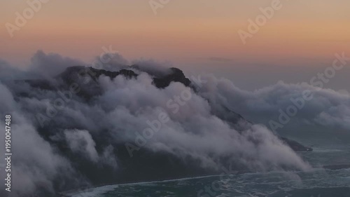 Aerial view of majestic mountains shrouded in ethereal clouds, where the sky meets the peak, Cape Town, Western Cape, South Africa.