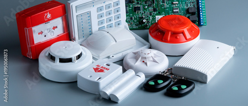 Collection of alarm system components shown on a gray surface for security setup