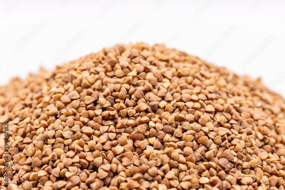 Obraz premium Macro buckwheat texture. Brown buckwheat seeds isolated on white background, close up. Buckwheat background.