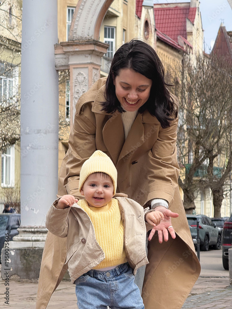 © phpetrunina14 - Mother holding toddler on city street in spring Portrait