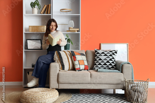 Young woman reading book on...