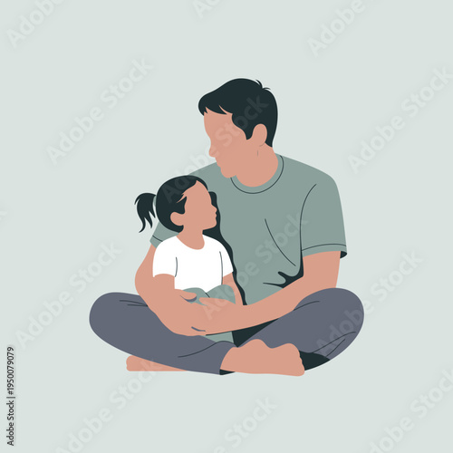 A father lovingly holds his child while seated on the floor.