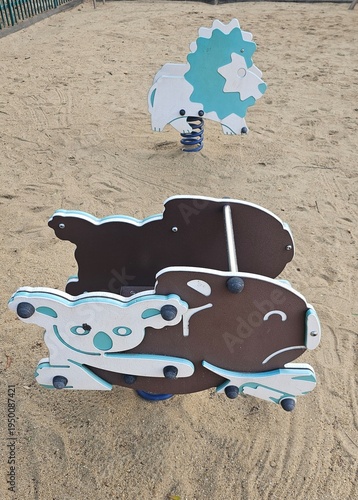 Spring rider playground equipment isolated on sand background