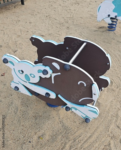 Spring rider playground equipment isolated on sand background