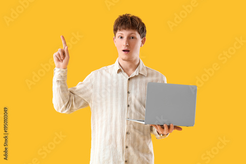 Young man with laptop point...