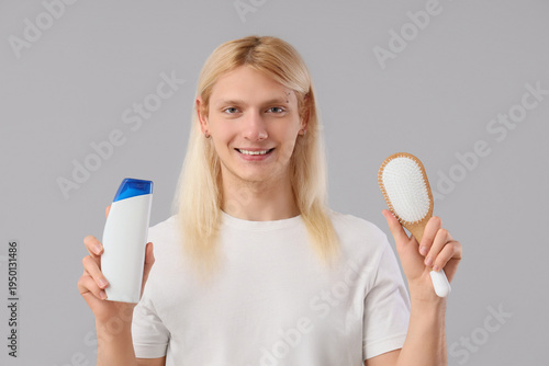 Young blonde man with shamp...