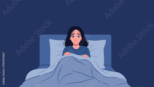 Young woman looking scared and anxious while lying in bed at night pulling the blue blankets up to her chin in a dark room.