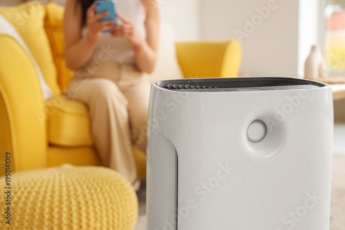 Woman adjusting air purifie...