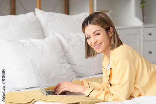Happy young woman using lap...