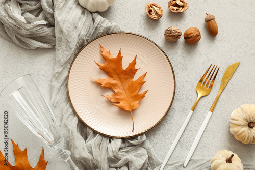 Beautiful table setting with autumn leaves, walnuts and pumpkins on white background