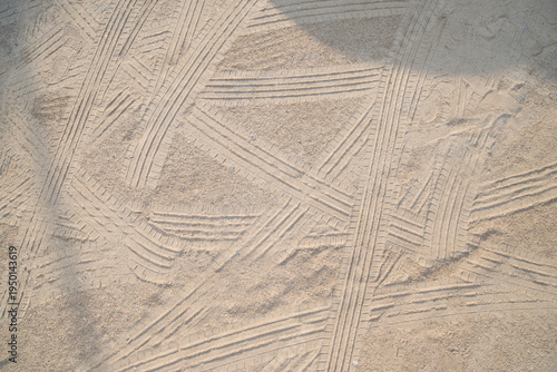 Traces of car tires on the sand in the park, closeup of photo