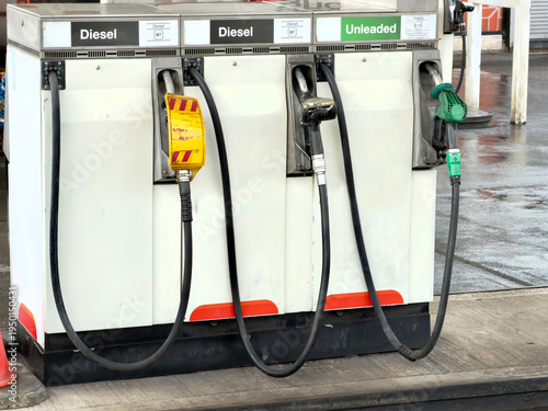 Fuel pumps on a petrol station forecourt showing petrol and diesel nozzles with one deisel pump showing gas is empty. 