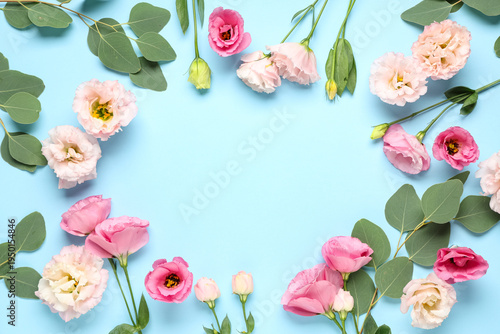 Frame in shape of heart made with beautiful flowers on blue background