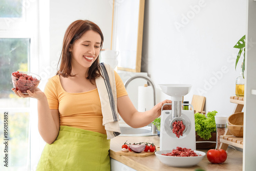 Young housewife using meat ...