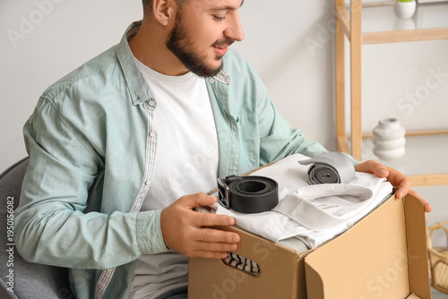 Young happy man unpacking c...