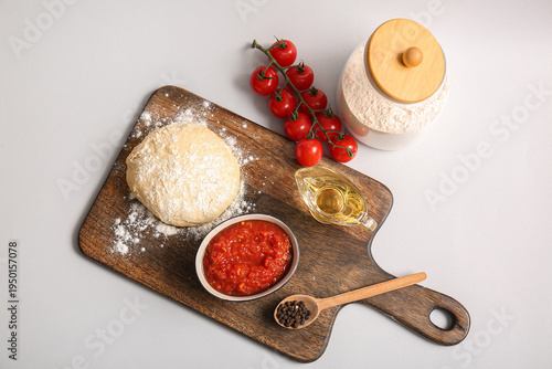 Board with raw dough, bowl ...