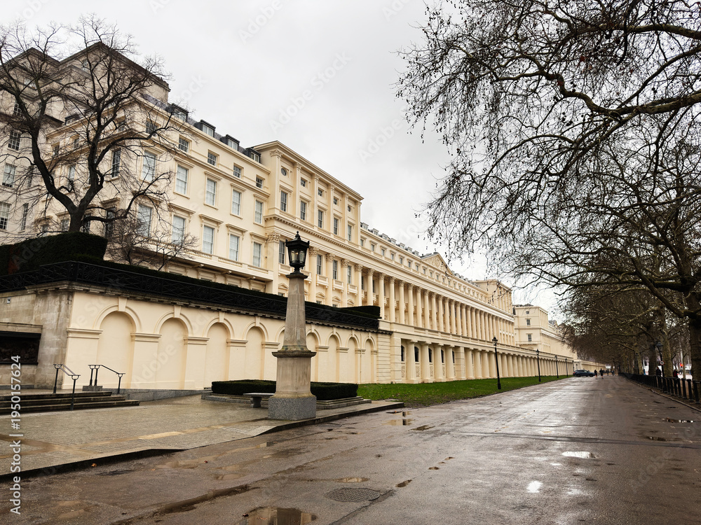 Fototapeta premium London, UK street view of grand beige Carlton House Terrace row with lampposts and bare trees