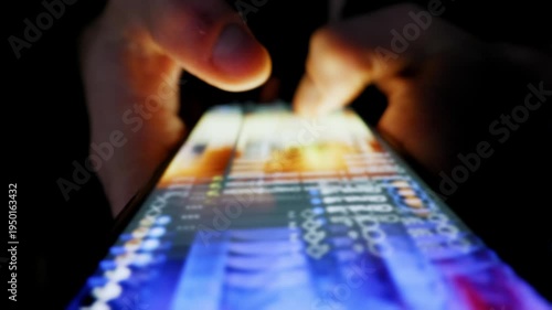 Hands scroll through an endless social media feed on a smartphone. The screen illuminates the fingers in an otherwise completely dark room.