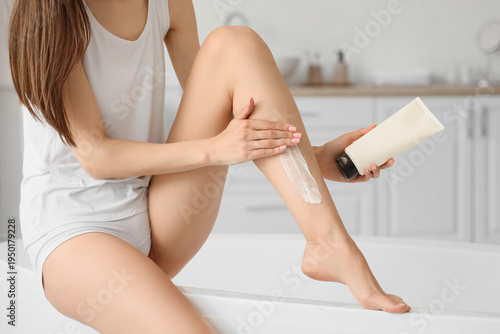 Young woman applying shavin...