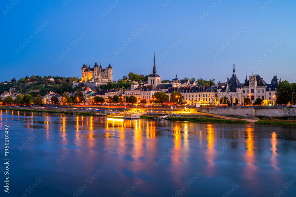 Fototapeta premium Long exposure of Saumur, Pays de la Loire, Northwestern France on summer evening at dusk. The Loire River flows through Saumur.