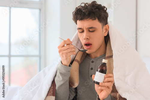Ill young man with spoon an...