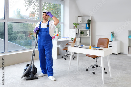 Janitor vacuuming floor in ...