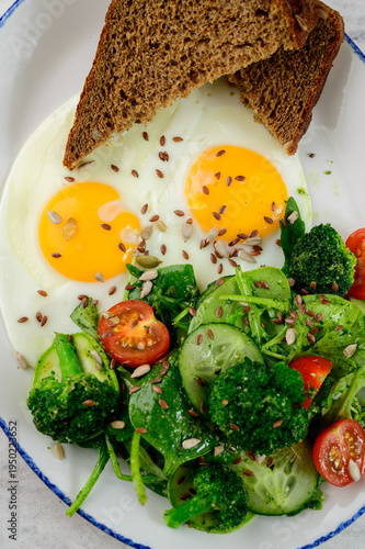 Breakfast plate with eggs, vegetables, and whole grain bread