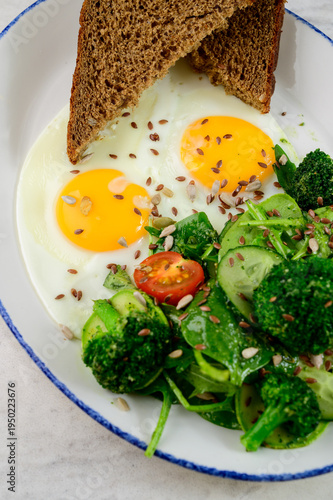 Breakfast plate with eggs, vegetables, and whole grain bread