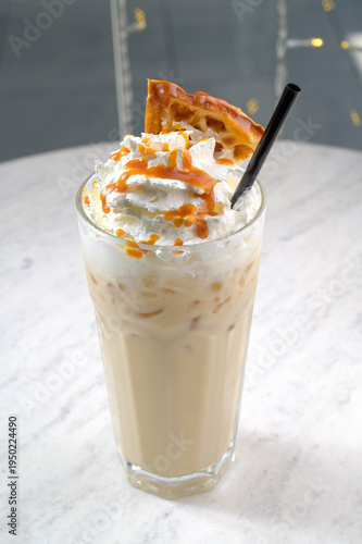 Iced coffee beverage topped with whipped cream and caramel drizzle