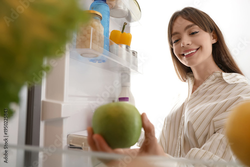 Young woman taking apple fr...
