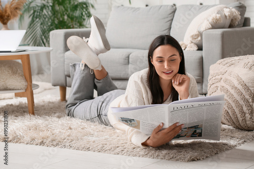 Young woman reading newspap...